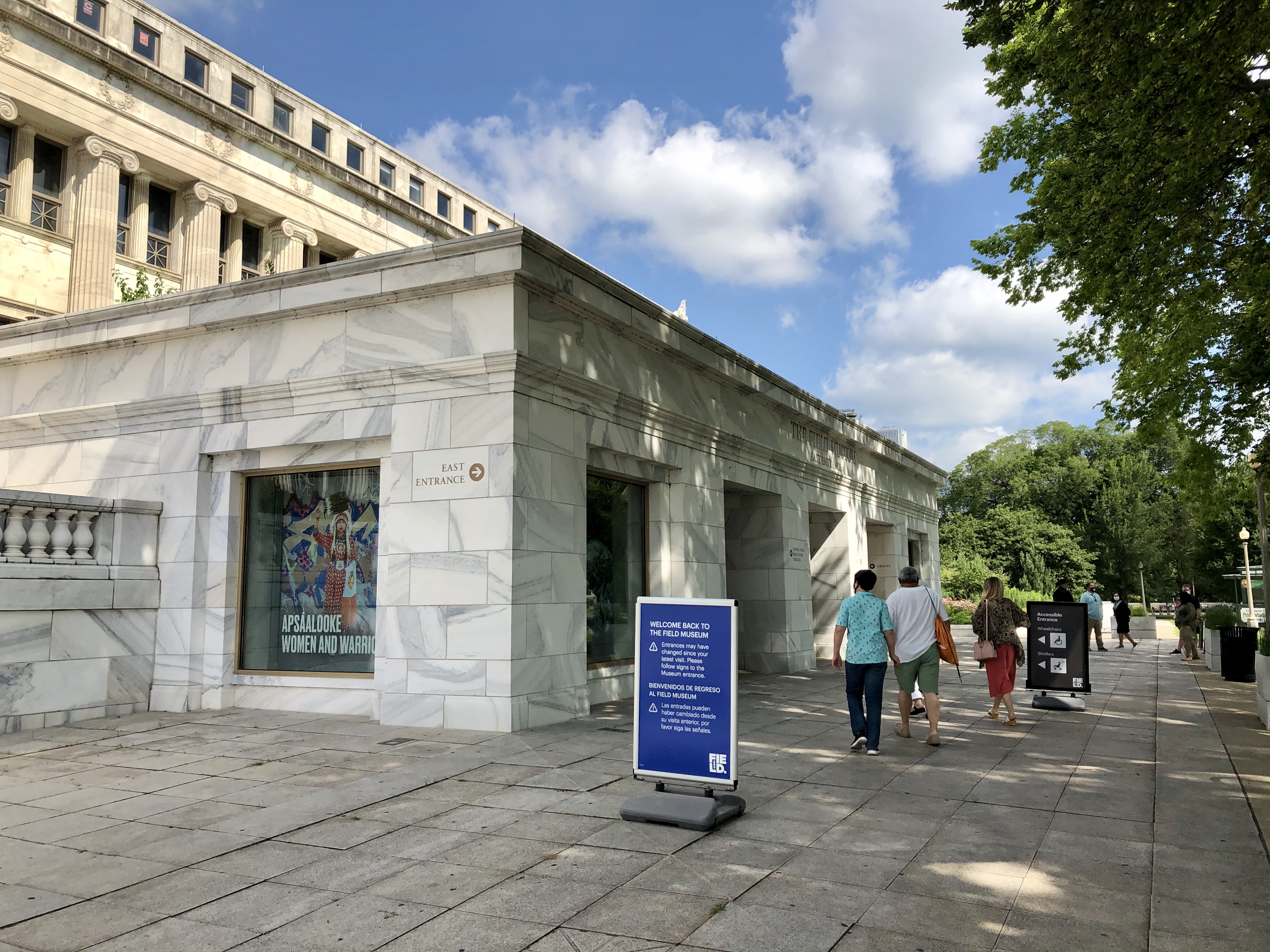 When you arrive, enter at the museum's East entrance, which is wheelchair-accessible. There is also a passenger drop-off area at the East entrance. Outside the Field Museum's East entrance. Three people walk towards the door.