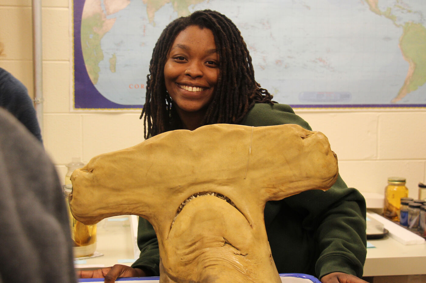 Media for Teens and Pre-teens A teen smiles while holding a preserved hammerhead shark