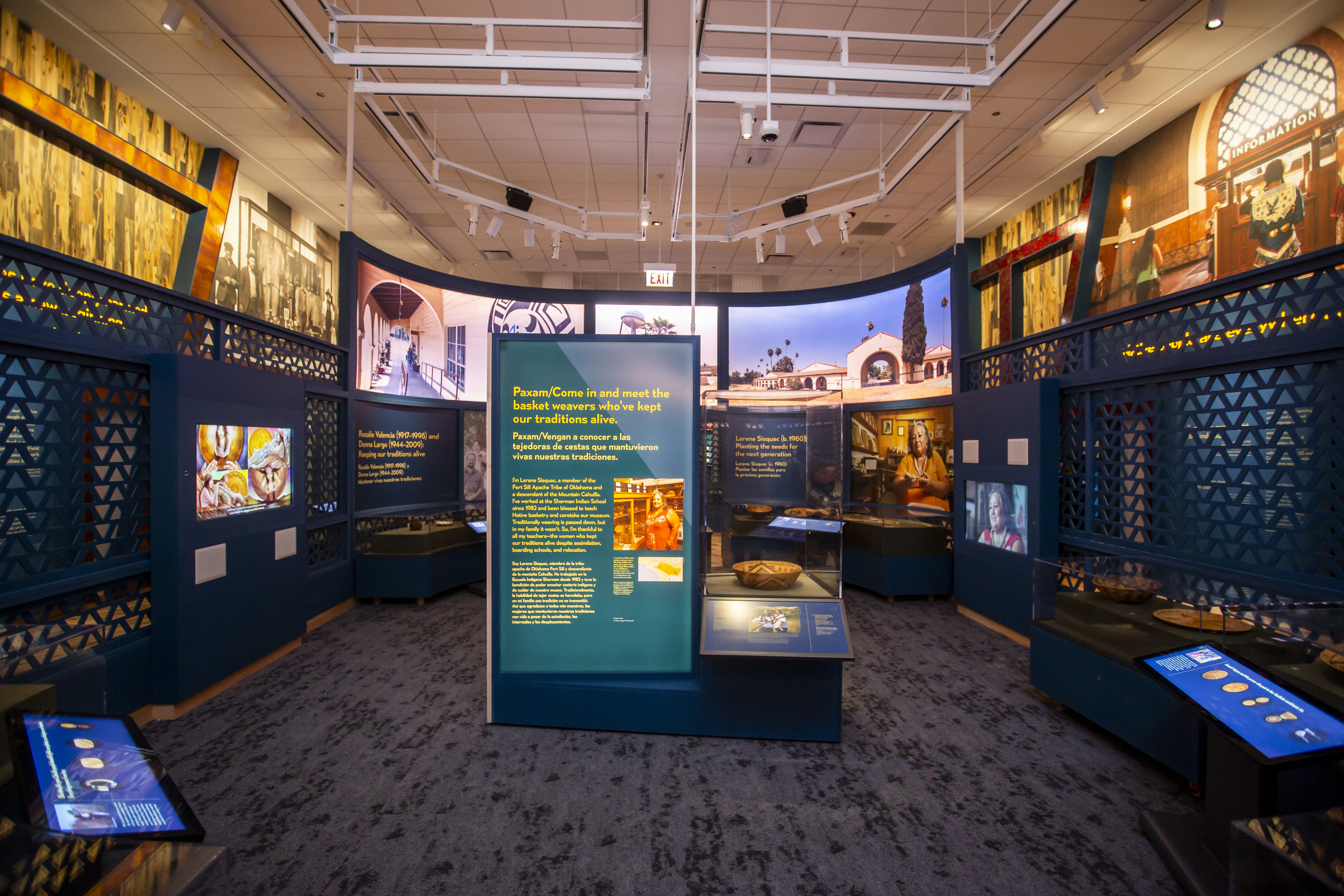 A museum exhibition with graphic panels, interactive displays, and multi-media monitors